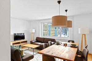 Apartment Via Surpunt - Ruben- 5 Rooms في سان موريتز: غرفة معيشة مع طاولة وأريكة