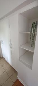 a closet with white cabinets and a green plant at StayMore in East London