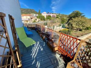 a balcony with chairs and a view of a street at APPARTEMENT DUPLEX - 100M DE LA PLAGE DE ST CLAIR in Le Lavandou