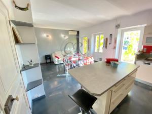 a kitchen and living room with a counter and a table at APPARTEMENT DUPLEX - 100M DE LA PLAGE DE ST CLAIR in Le Lavandou