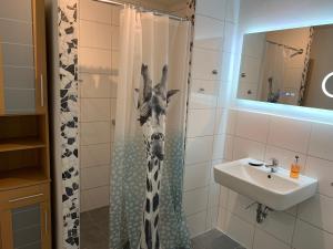 Baño con cabeza de jirafa en la cortina de la ducha en Appartement Martha, en Laufenburg