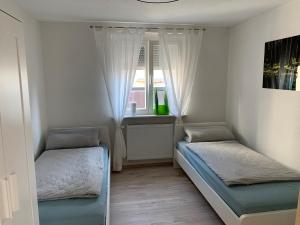 1 dormitorio con 2 camas y ventana en Appartement Martha, en Laufenburg
