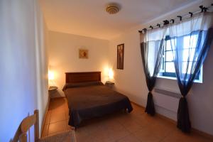 um quarto com uma cama e uma janela em GITE DES MOINES-Canelle em Canari