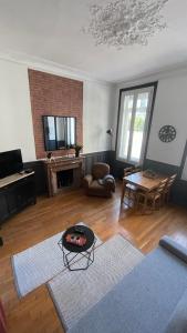 a living room with a couch and a table at L industriel rémois, centre ville, proche de la cathédrale in Reims