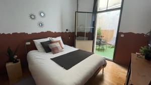 1 dormitorio con 1 cama con sábanas y almohadas blancas en L industriel rémois, centre ville, proche de la cathédrale, en Reims