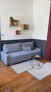a living room with a blue couch and a table at L industriel rémois, centre ville, proche de la cathédrale in Reims