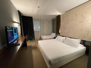A bed or beds in a room at Bes Hotel Cremona Soncino