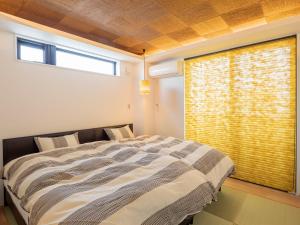 a bedroom with a large bed and a window at Family Inn Kei 慶 in Kyoto