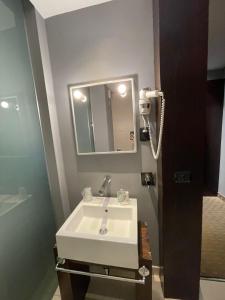 ein Badezimmer mit einem weißen Waschbecken und einem Spiegel in der Unterkunft Bes Hotel Cremona Soncino in Soncino