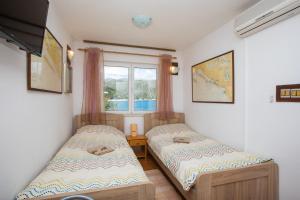 2 Einzelbetten in einem Zimmer mit Fenster in der Unterkunft Seaside Studio in Zaton