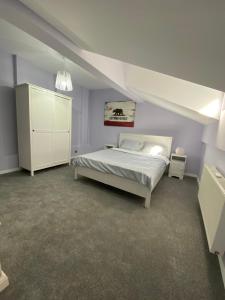 a bedroom with a white bed and a white cabinet at House Boutique Clucerului in Bucharest