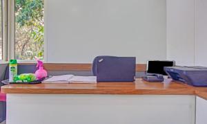 un bancone da ufficio con scrivania e computer portatile di Treebo Trend Shalimar In The Forest Matheran a Matheran