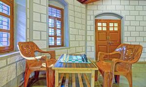 ein Zimmer mit einem Schachspiel auf einem Tisch und 2 Stühlen in der Unterkunft Treebo Trend Shalimar In The Forest Matheran in Matheran