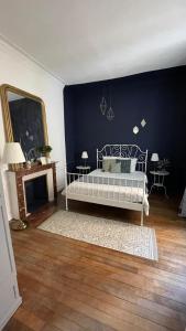 a bedroom with a bed and a blue wall at Le classique champenois, centre ville, proche cathédrale in Reims