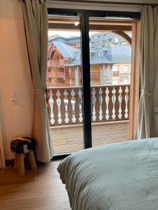 um quarto com uma janela com vista para uma varanda em L' Etoile du Pic em La Mongie