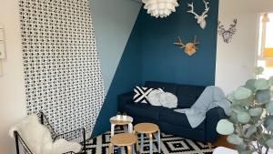 un salon avec un canapé bleu et un mur bleu dans l'établissement Le Grand Est Scandinave, centre ville, proche cathédrale, à Reims