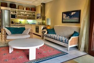 salon z 2 kanapami i stołem w obiekcie Bigarade Suite by Simply-Seychelles w mieście Eden Island