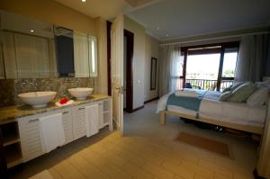 sypialnia z 2 umywalkami i łóżkiem z oknem w obiekcie Bigarade Suite by Simply-Seychelles w mieście Eden Island