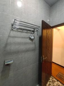 a bathroom with a door and a tile wall at Mudhia Homestay in Magelang