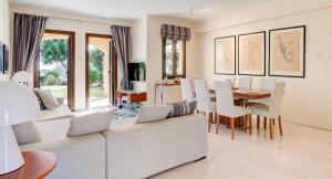 un soggiorno con un divano bianco e un tavolo di Ground floor apartment with golf and sea views - Roudias, Aphrodite Hills Resort a Kouklia