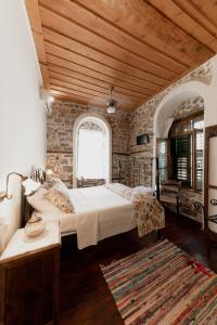 una camera con due letti e un muro di pietra di Rigas Pension Nafplio a Nauplia