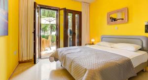 una camera da letto con un letto con una parete gialla di Ground floor apartment with golf and sea views - Roudias, Aphrodite Hills Resort a Kouklia Altre 30 foto