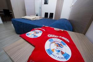 a room with a bed and a red shirt on the floor at Ciccio Hotel in Misano Adriatico