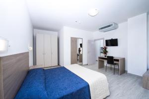 a bedroom with a blue bed and a desk at Ciccio Hotel in Misano Adriatico +59 photos