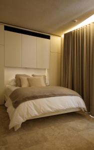 1 dormitorio con 1 cama grande con almohadas blancas en The King George Village Boutique Living, en Għargħur