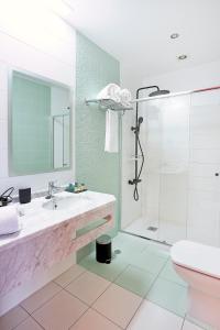 a bathroom with a shower and a sink and a toilet at Hotel Rincón del Conde in León +18 photos