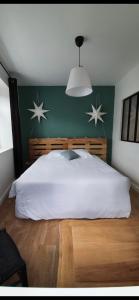 a bedroom with a large white bed with stars on the wall at La tête dans les étoiles in Aumont