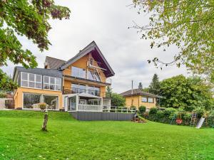 ein Haus mit grünem Rasen davor in der Unterkunft Haus Eifelsonne in Hellenthal