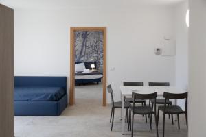 sala de estar con mesa, sillas y cama en Residence Molino - Holiday Apartments, en Manerba del Garda