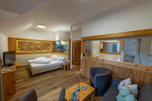 魏森湖Hotel zum Weissensee的带床和电视的客厅