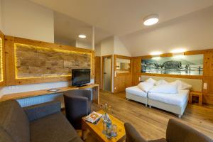 a hotel room with a bed and a tv at Hotel zum Weissensee in Weissensee