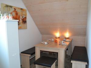 a wooden table with benches in a room at Ferienwohnung Seeliebe in Radolfzell am Bodensee