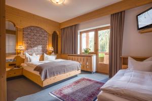 una camera d'albergo con due letti e una televisione di Hotel Almhof a Hochfugen