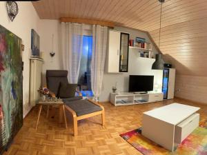 a living room with a couch and a tv at Ferienwohnung Seeliebe in Radolfzell am Bodensee