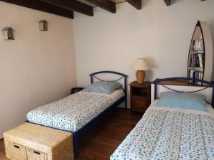 ein Schlafzimmer mit zwei Betten und einem Tisch mit Spiegel in der Unterkunft GITE AVEL BREIZH in Roz-sur-Couesnon