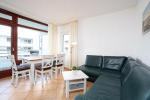 sala de estar con sofá verde y mesa en Grömitz Center II Wohnung 40, en Grömitz