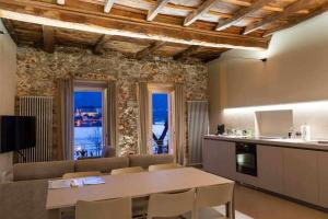 cocina y sala de estar con mesa y sillas en Orta Paradise 6, en Orta San Giulio