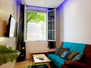a living room with a blue couch and a window at Le Chateau in Angers