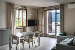 sala de estar con mesa, sillas y sofá en Orta Paradise 26 en Orta San Giulio