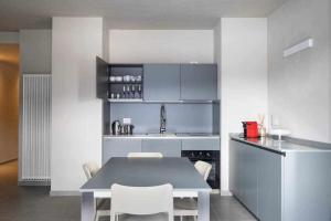 a kitchen with a table and some white chairs at Orta Paradise 26 in Orta San Giulio