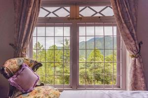 d'une fenêtre avec une chaise et une vue sur la montagne. dans l'établissement Seclude Ramgarh Taradale, à Rāmgarh