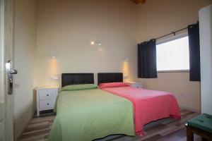 Apartamentos Rurales Miramar في Pimiango: غرفة نوم بسرير وبطانية وردية وأخضر