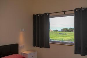 a bedroom with a window with a view of a field at Apartamentos Rurales Miramar in Pimiango
