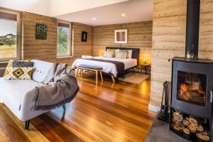 een woonkamer met een bed en een open haard bij Ecopia Retreat in Seal Bay +73 foto's