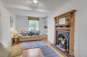 sala de estar con chimenea y sofá en Guest Homes - The Lodge, en Earlham