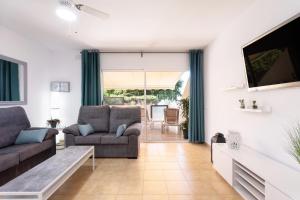 a living room with a couch and a tv at Gigantes Cliff Holiday Home by Sydney Playa Sur in Acantilado de los Gigantes